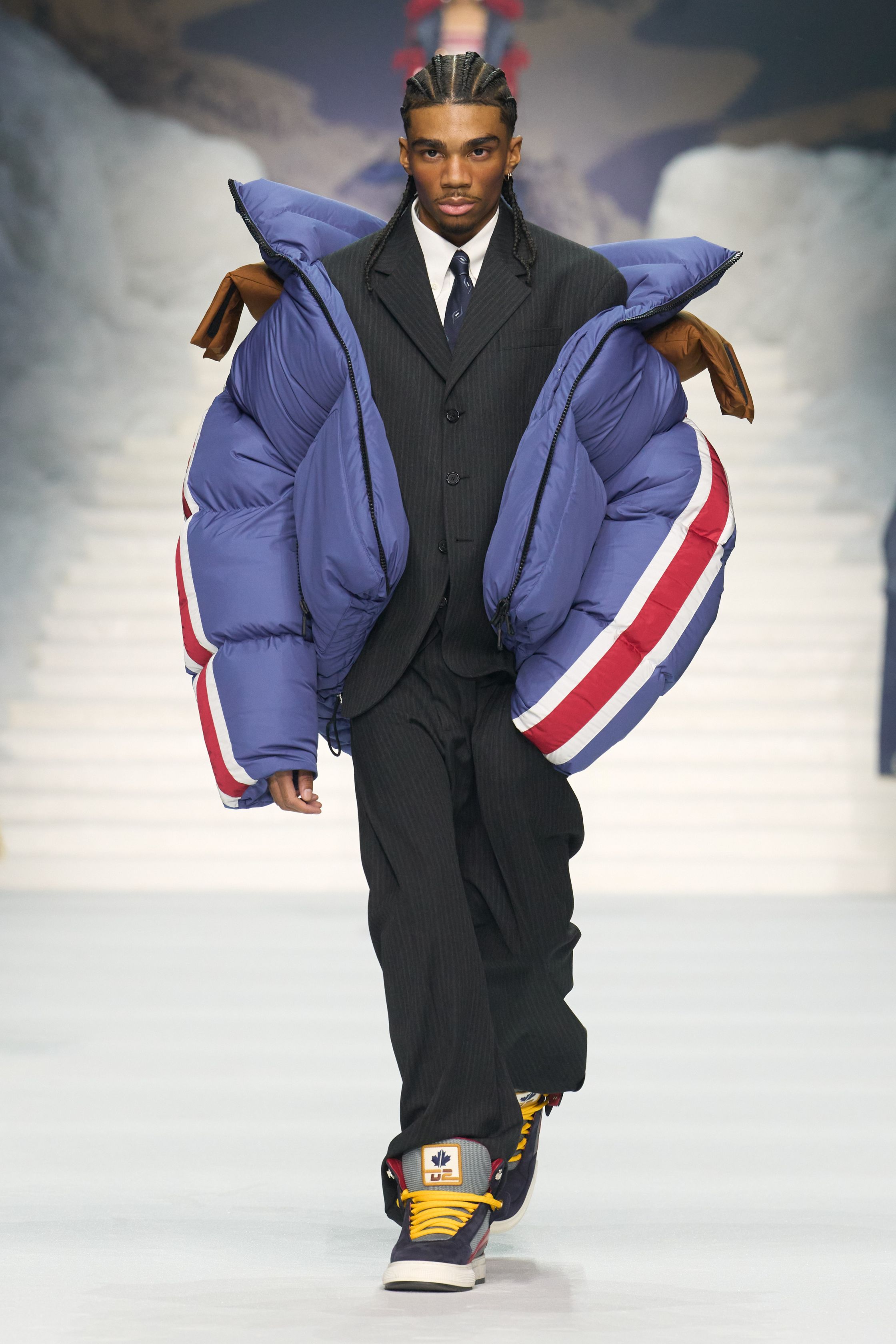 Dsquared2 2026秋冬以夸张的滑雪场景为背景，将加拿大户外精神、Y2K 性感与舞台化时装推至极致。羽绒、毛皮、紧身牛仔与夸张比例不断叠加，身体成为视觉焦点，性感、力量与炫耀被无限放大。这不是现实主义的衣橱，而是一场关于冒险、欲望与表演的时尚狂欢，张扬而直接，忠于品牌一贯的高能量叙事-顽石频道趋势研究